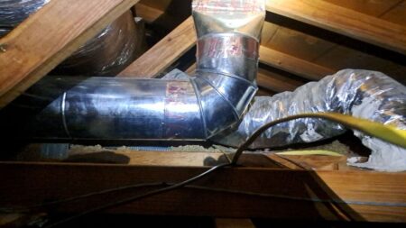 Custom galvanized HVAC supply duct connected to insulated attic ductwork during installation