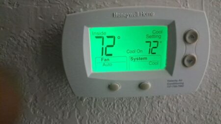 Honeywell programmable thermostat displaying cooling mode and indoor temperature settings