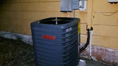 Goodman outdoor air conditioner condenser installed on a new concrete pad during residential AC replacement