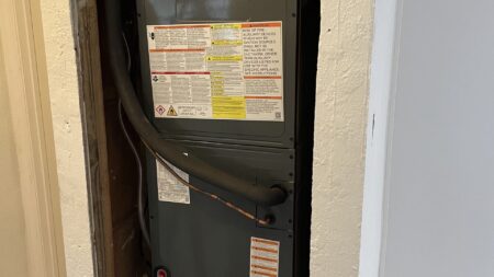 Residential air handler installation in a laundry room with insulated supply plenum and return air system