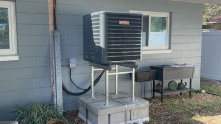Goodman outdoor air conditioning condenser installed on an elevated stand for improved flood protection