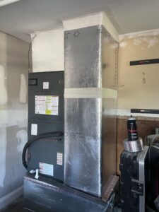 Residential air conditioner condenser installation on raised platform with professional refrigerant line routing