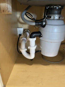 Professional garbage disposal installation with plumbing connections