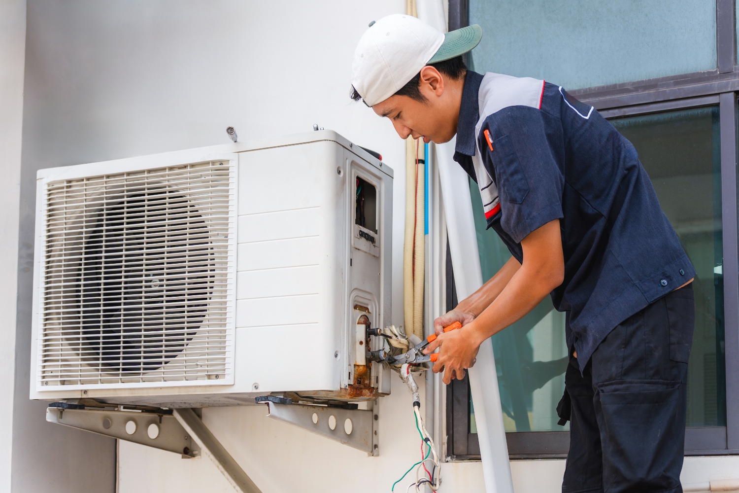 HVAC technician diagnosing air conditioner